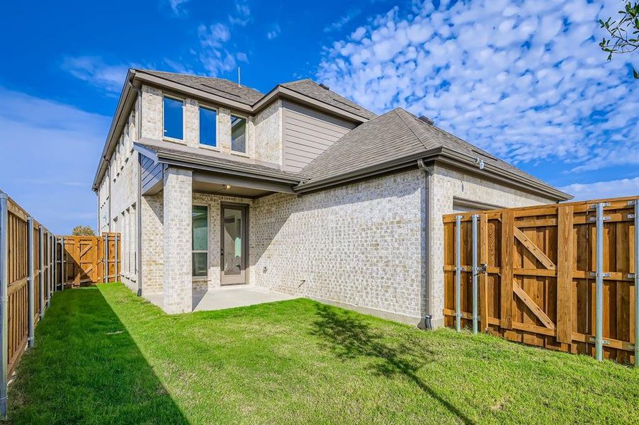 Back of property featuring a gate, a patio area, brick siding, a fenced backyard, and a shingled roof Back of property featuring a gate, a patio area, brick siding, a fenced backyard, and a shingled roof
