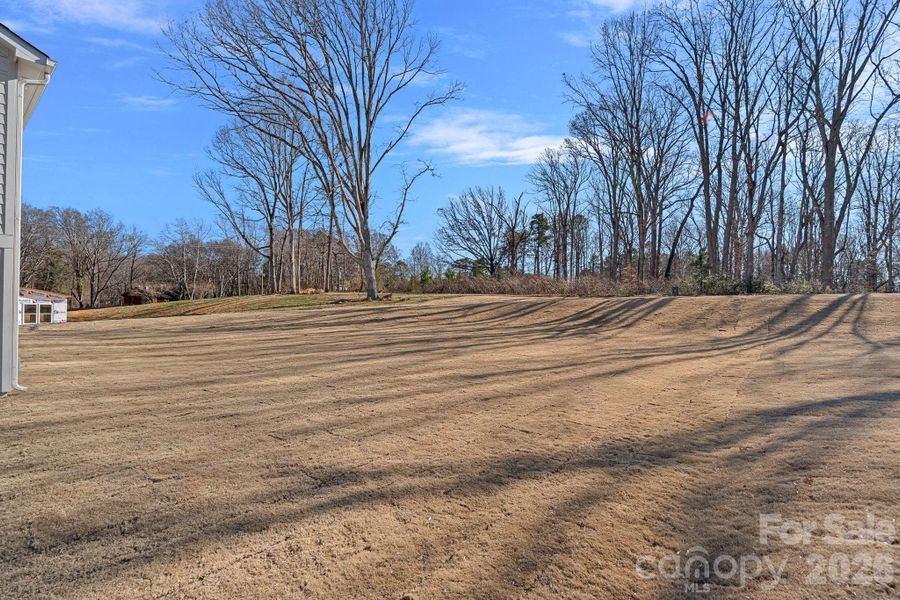 A beautifully landscaped HALF ACRE homesite with peaceful views of mature trees.