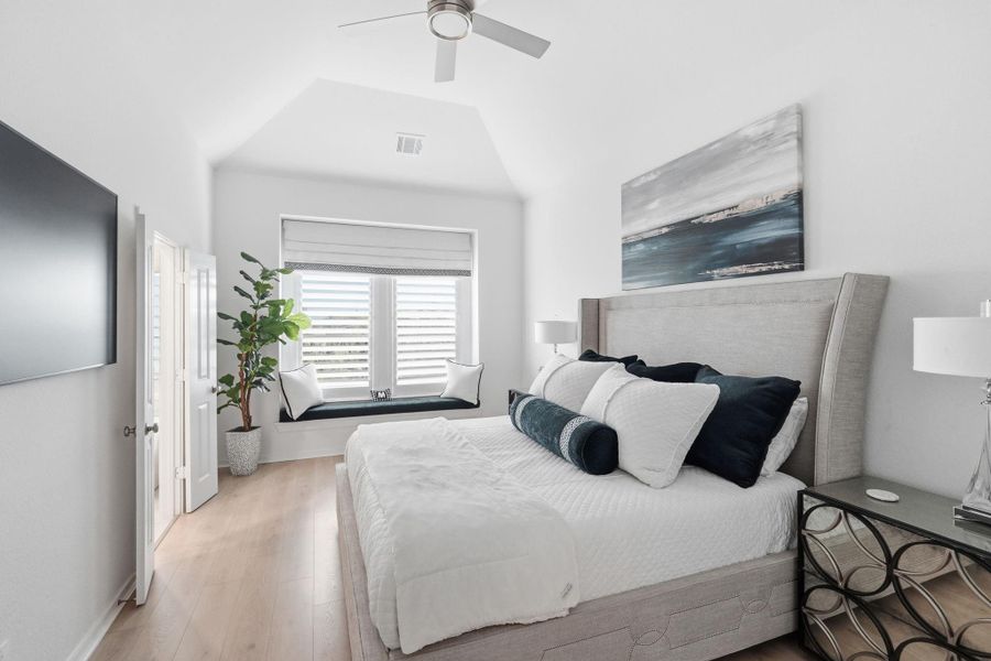 Luxurious primary bedroom featuring a cozy reading nook, abundant natural light, and elegant decor for a serene retreat.