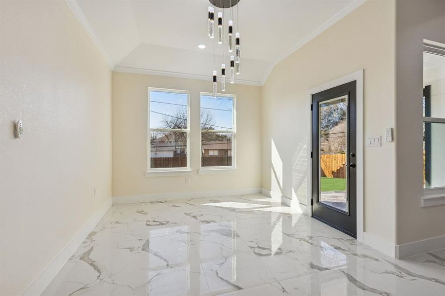Unfurnished dining area with crown molding and marble tiled flooring