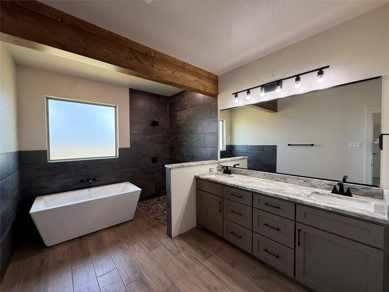 Indulge in this bathroom featuring a freestanding tub and a spacious double vanity.