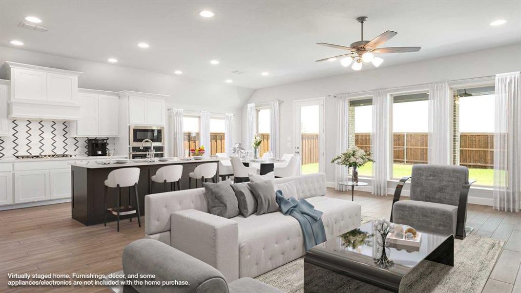 Living room featuring light wood-type flooring, lofted ceiling, sink, and ceiling fan