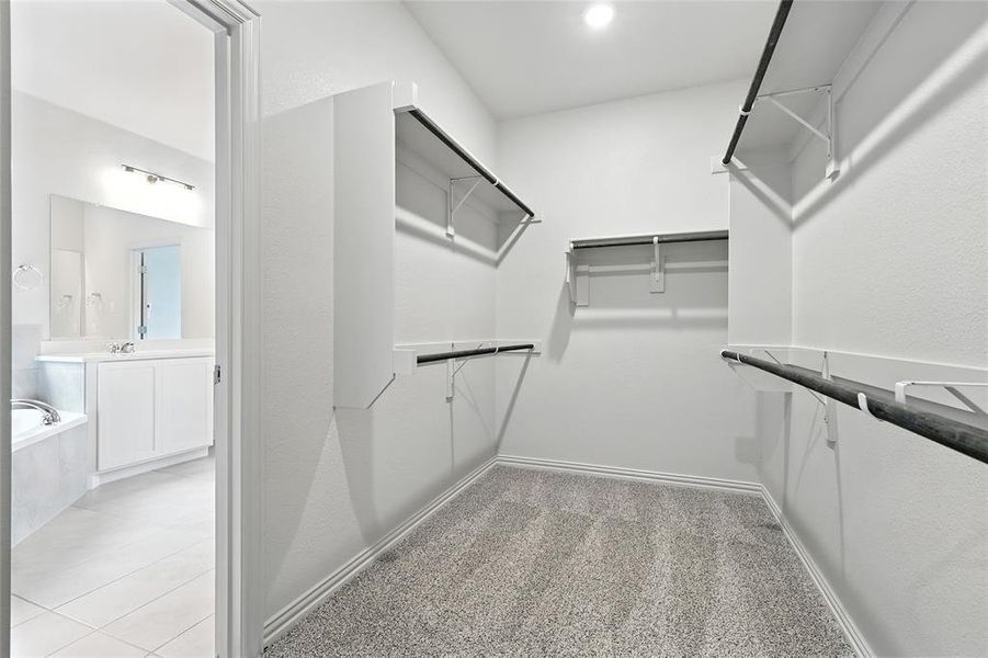 Walk in closet featuring light carpet and light tile patterned flooring
