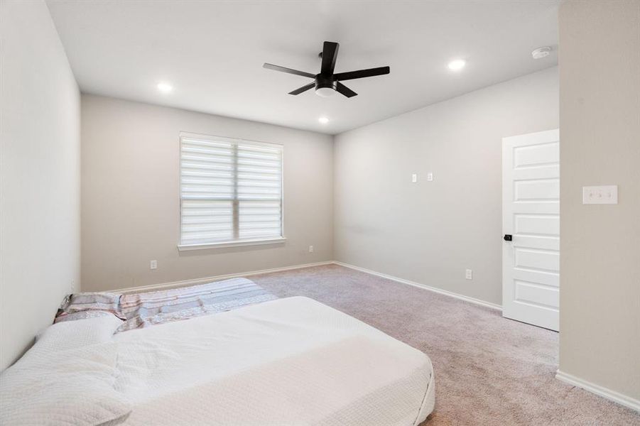 Carpeted bedroom featuring a ceiling fan and recessed lighting Carpeted bedroom featuring a ceiling fan and recessed lighting