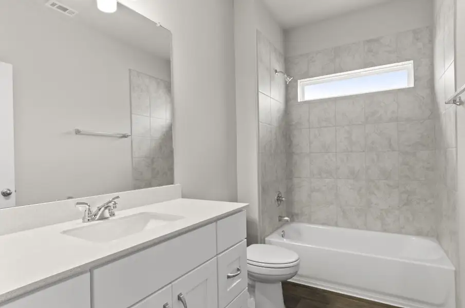 Full bathroom featuring vanity, wood finished floors, and washtub / shower combination