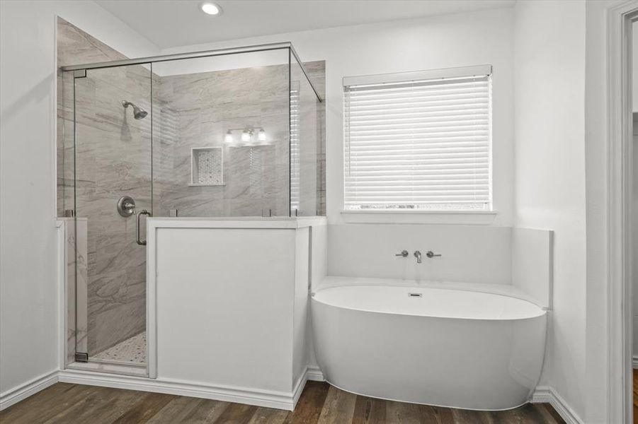 Bathroom featuring hardwood / wood-style floors and plus walk in shower