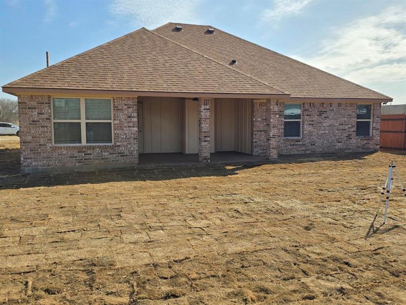 Rear view of property featuring a patio, brick siding, and a shingled roof Rear view of property featuring a patio, brick siding, and a shingled roof