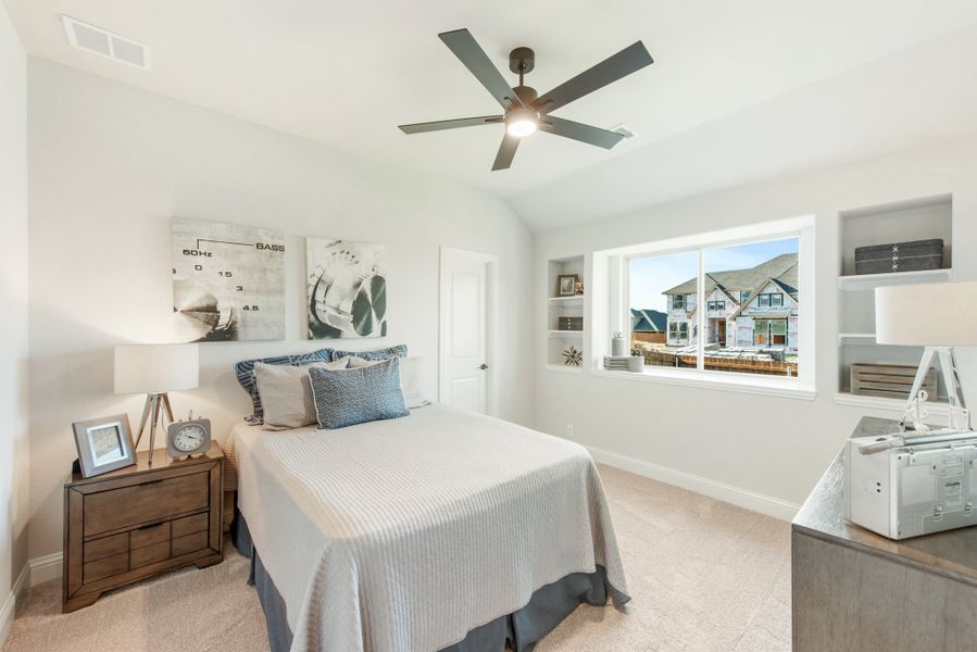 Bedroom with vaulted ceiling, ceiling fan, built-in shelves, and large window with neighborhood view