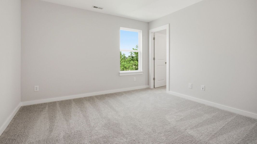 Bedroom with carpet, window, and walk-in closet Bedroom with carpet, window, and walk-in closet