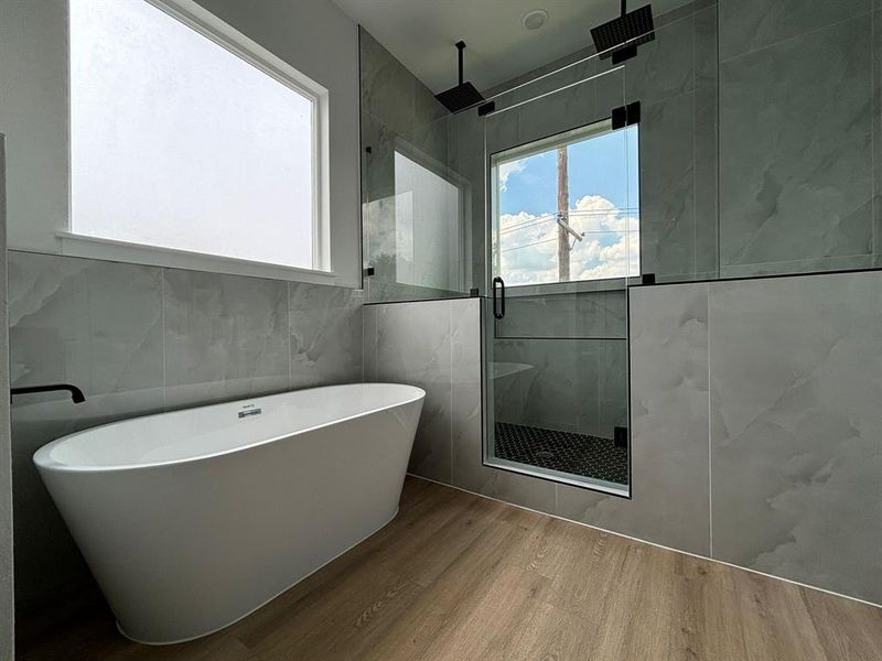 Spa-like bath boasts Quartz countertops, dual vanities, soaking tub, and oversized shower area with dual rain shower heads.