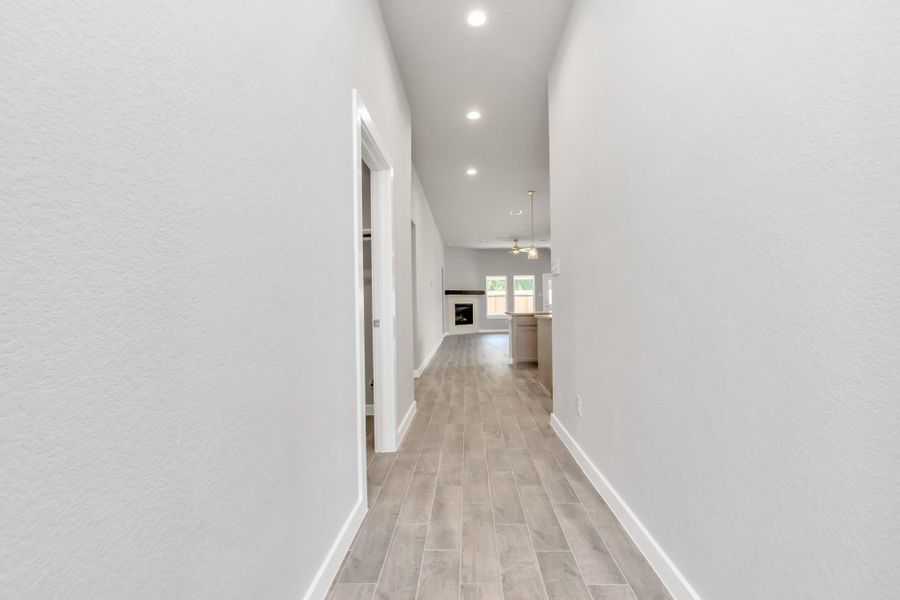 The majestic entryway allures with its high ceilings, embellished with sophisticated wood-look tile flooring and sleek oversized baseboards. Sample photo of completed home with similar floor plan. As-built interior colors and selections may vary. The majestic entryway allures with its high ceilings, embellished with sophisticated wood-look tile flooring and sleek oversized baseboards. Sample photo of completed home with similar floor plan. As-built interior colors and selections may vary.