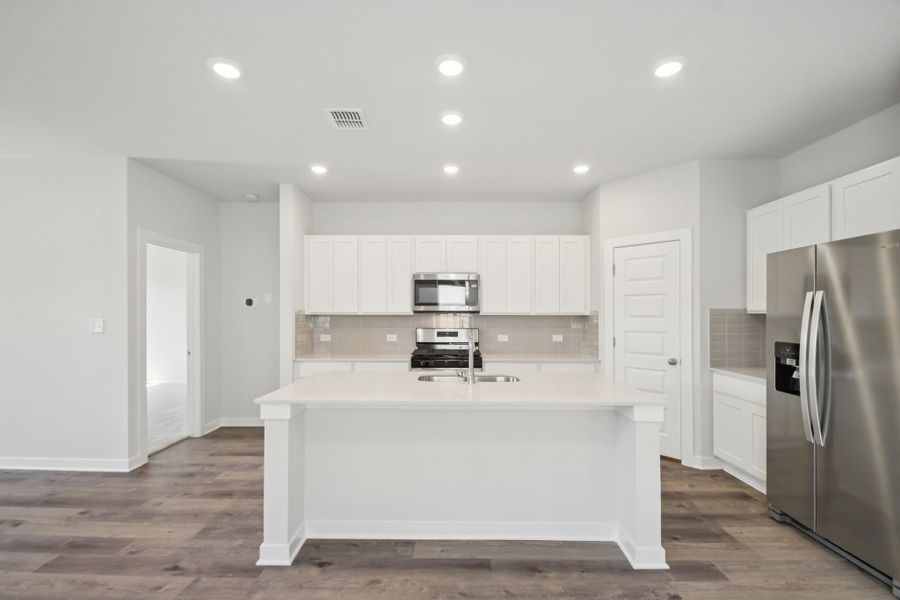 A kitchen with white cabinets.