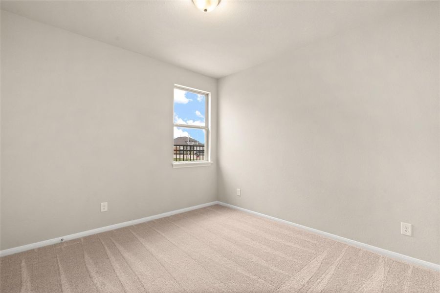 This secondary bedroom is perfect for an in-law suite. Featuring plush carpet, fresh paint, closet, large window, and has direct access to the secondary bathroom.