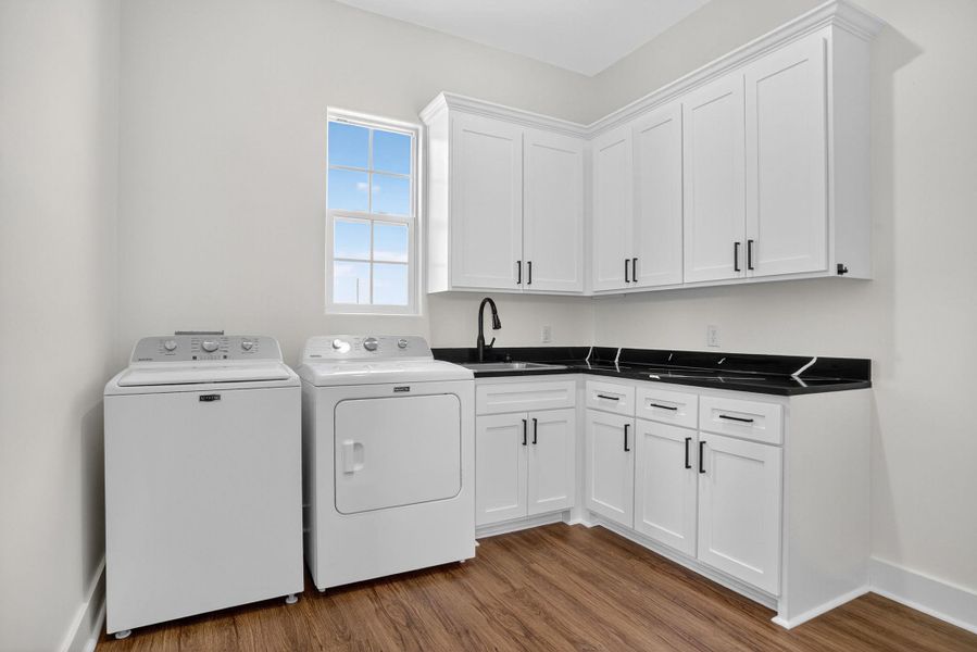 Laundry room featuring dark wood-type flooring, cabinet space, and independent washer and dryer Laundry room featuring dark wood-type flooring, cabinet space, and independent washer and dryer