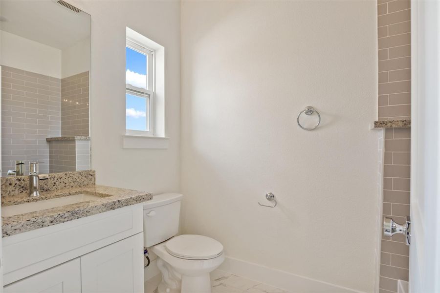 The secondary bathroom features abundant natural light and a convenient shower-tub combo!