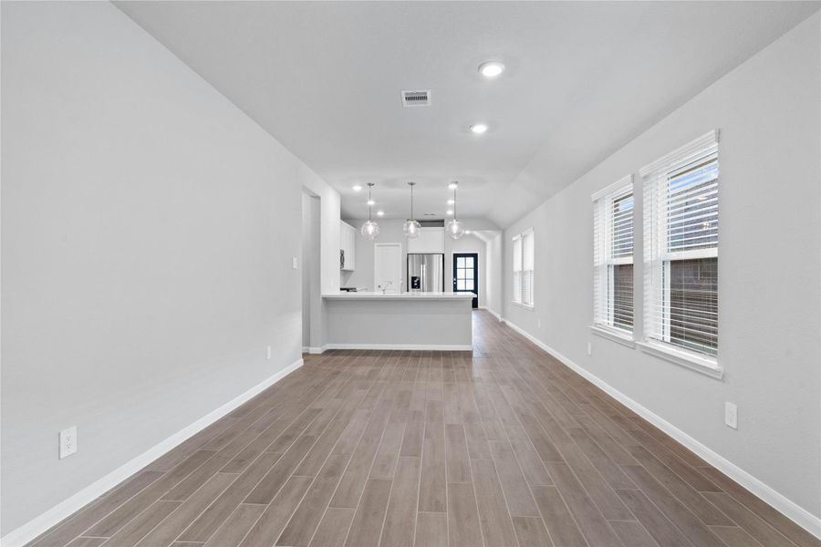 Enjoy meals in this sun-drenched space, featuring durable tile flooring, abundant natural light from the large windows (fitted with blinds), and recessed lighting.