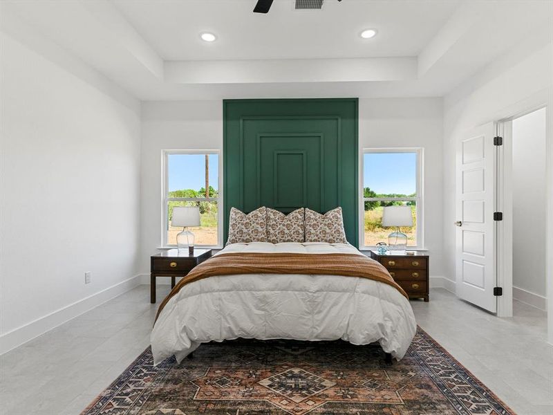 Bedroom with multiple windows, a tray ceiling, a ceiling fan, and recessed lighting