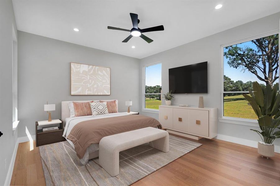 Recessed lighting and a ceiling fan fixture illuminate this space, featuring wood-finish flooring