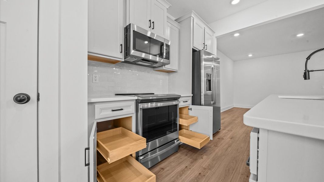 Exceptional kitchen featuring a spacious island, eye-catching pendant lights, and modern finishes located in Arden, NC