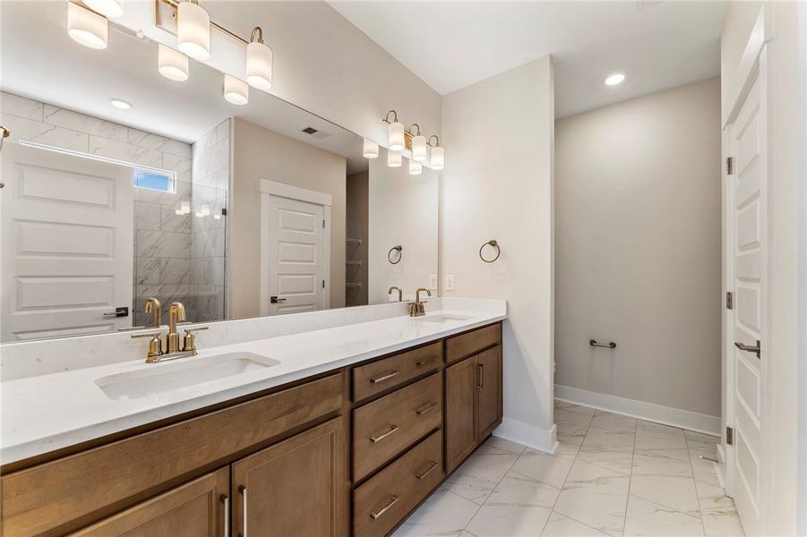 This spacious bathroom features a dual vanity and This spacious bathroom features a dual vanity and