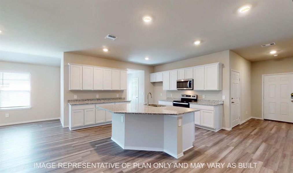 Kitchen featuring an island with a sink, white cabinetry, granite-style countertops, stainless steel microwave, and wood-finish flooring Kitchen featuring an island with a sink, white cabinetry, granite-style countertops, stainless steel microwave, and wood-finish flooring