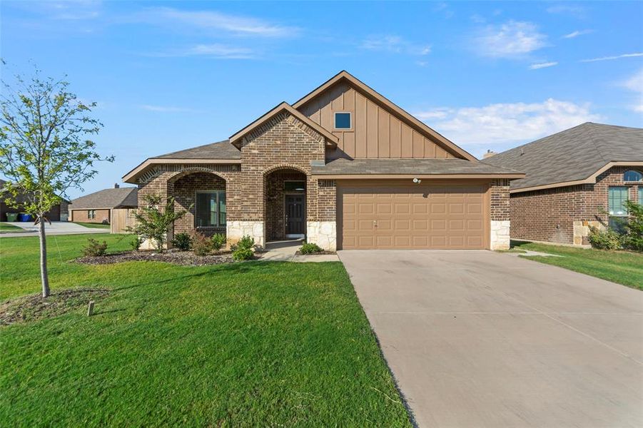 View of front of house featuring a garage and a front lawn