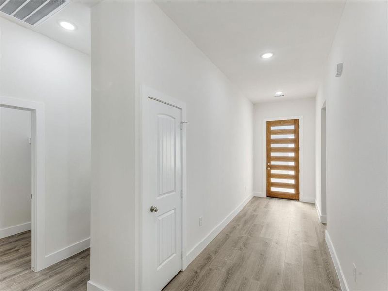 Hall featuring light wood finished floors and recessed lighting