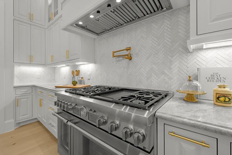 Gourmet kitchen featuring a 6-burner stove with griddle and a convenient pot filler, perfect for culinary enthusiasts and entertaining. Gourmet kitchen featuring a 6-burner stove with griddle and a convenient pot filler, perfect for culinary enthusiasts and entertaining.