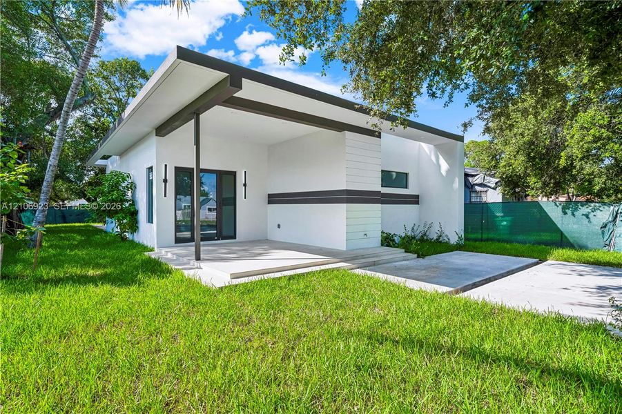 Modern exterior featuring a flat roofline, integrated covered patio, horizontal siding accents, and concrete hardscaping Modern exterior featuring a flat roofline, integrated covered patio, horizontal siding accents, and concrete hardscaping