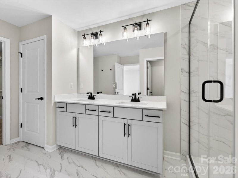 Owners bathroom with Dual vanity soft close doors & drawers, tiled shower with bench