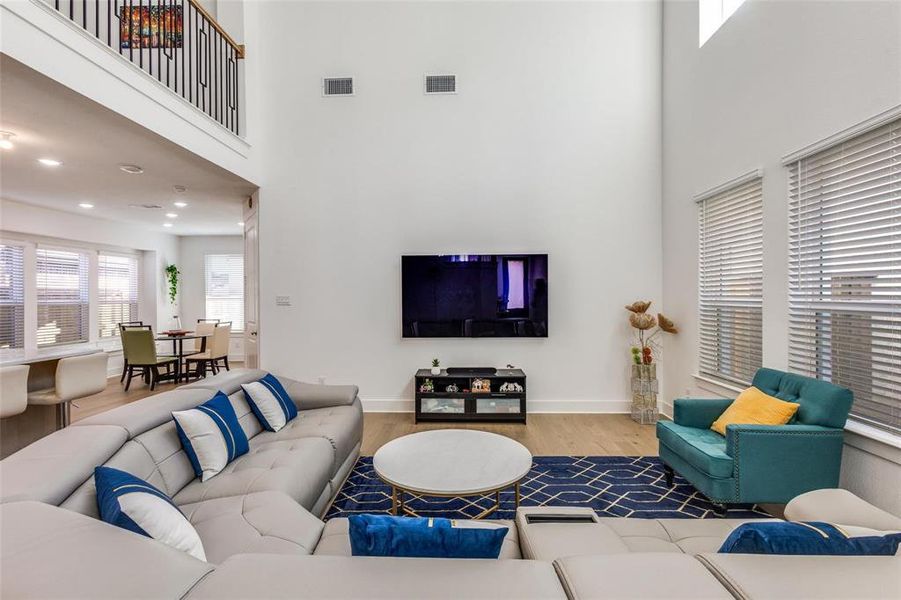 Living room with a high ceiling and wood finished floors Living room with a high ceiling and wood finished floors