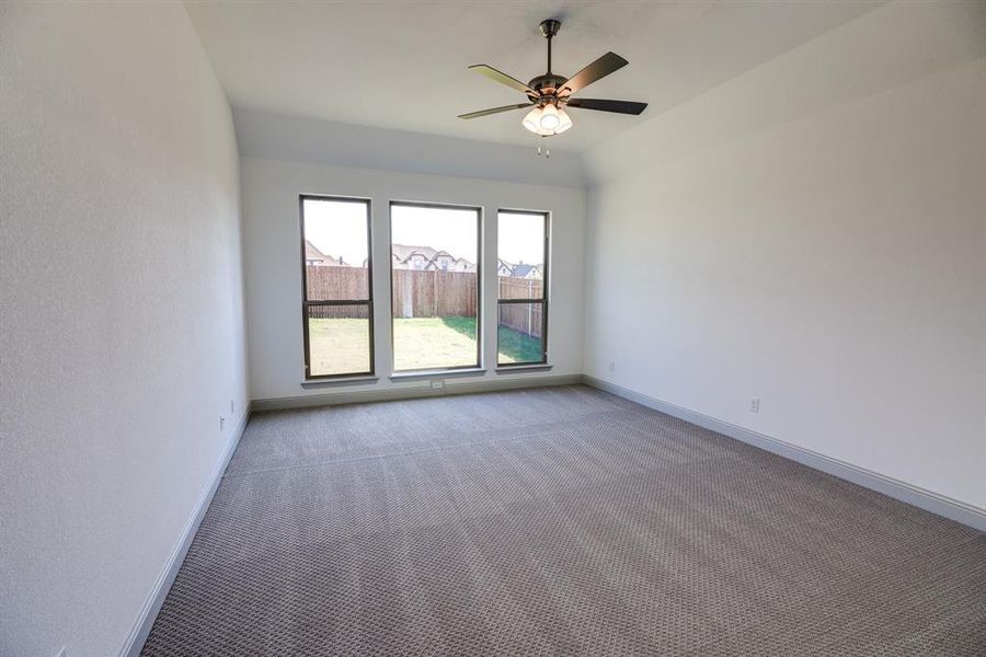 Carpeted spare room featuring baseboards and a ceiling fan Carpeted spare room featuring baseboards and a ceiling fan