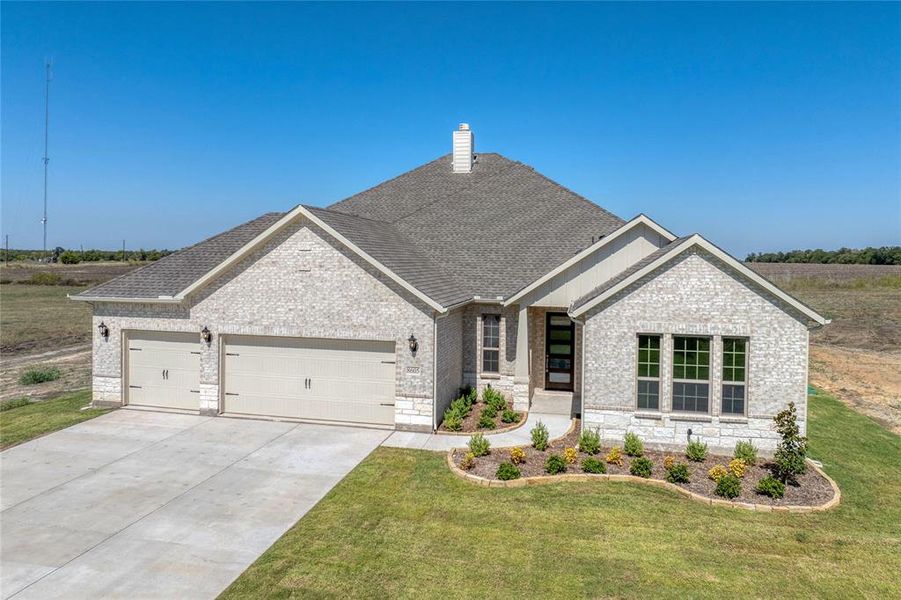 Craftsman house featuring a garage and a front lawn