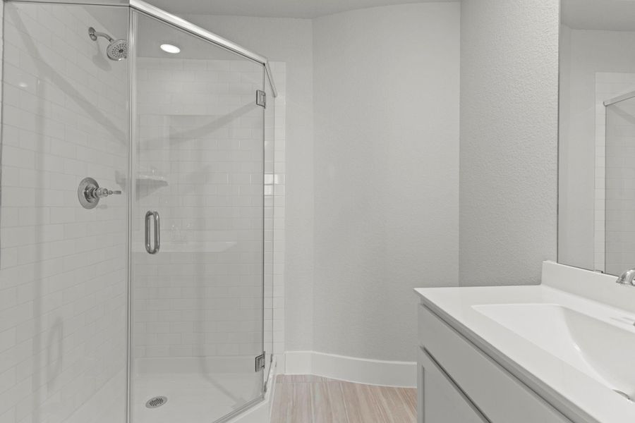 A closer look at the secondary bath highlights the sleek walk-in shower surrounded by contemporary tilework and polished fixtures—easy to maintain and beautifully designed for everyday living.