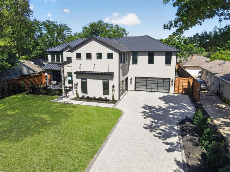 Modern contemporary residence featuring a light-colored stucco exterior, dark metal roof, and large format windows Modern contemporary residence featuring a light-colored stucco exterior, dark metal roof, and large format windows