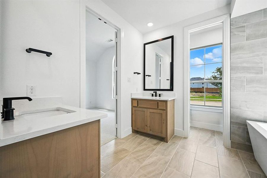 Bathroom featuring two vanities, a freestanding bath, and recessed lighting Bathroom featuring two vanities, a freestanding bath, and recessed lighting