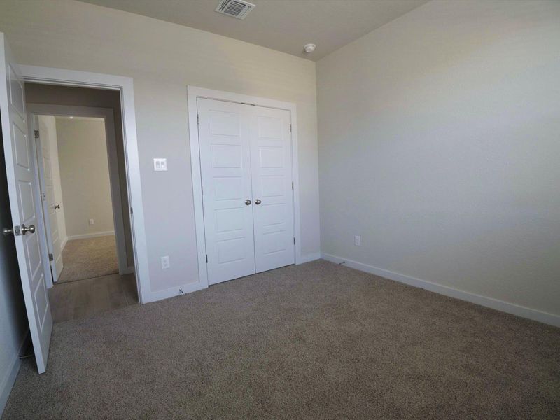 Unfurnished bedroom with carpet floors and a closet Unfurnished bedroom with carpet floors and a closet