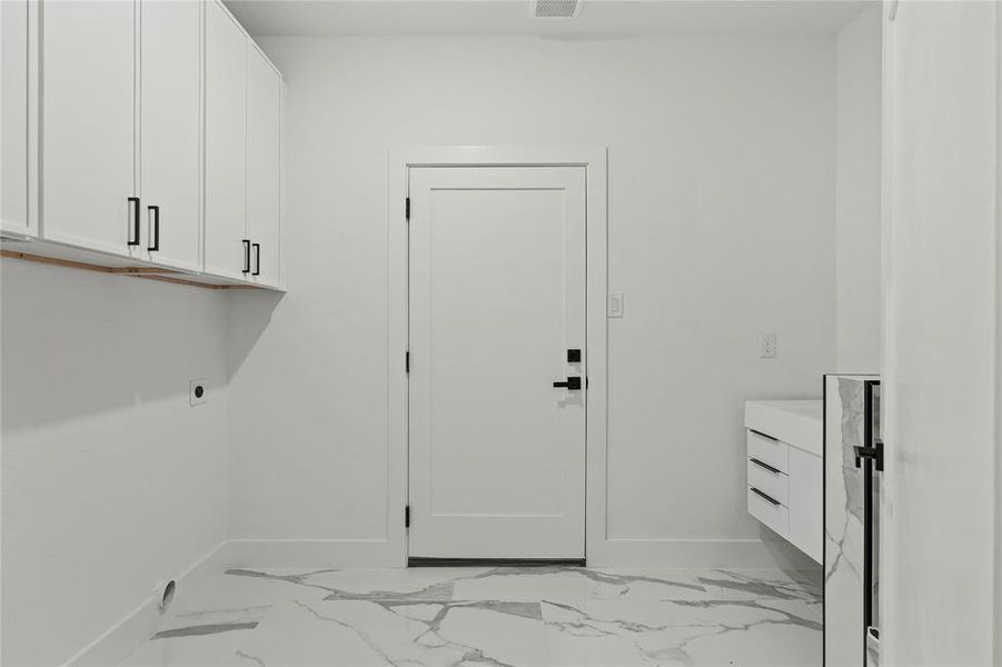 Washroom featuring cabinet space, light marble finish floors, and hookup for an electric dryer Washroom featuring cabinet space, light marble finish floors, and hookup for an electric dryer