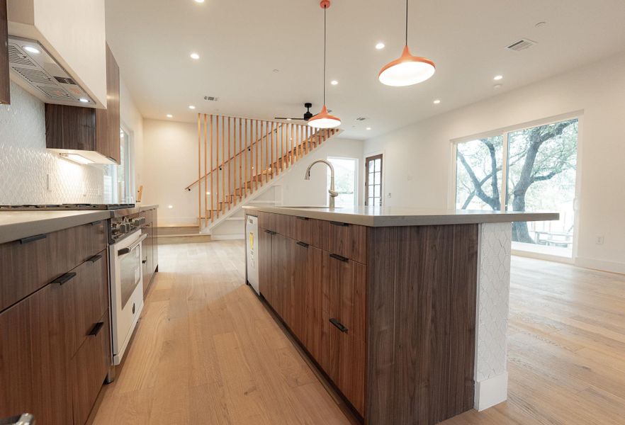 A contemporary kitchen and open living space offer effortless movement and light-filled views. Gather around the sleek concrete-look quartz countertops. A contemporary kitchen and open living space offer effortless movement and light-filled views. Gather around the sleek concrete-look quartz countertops.