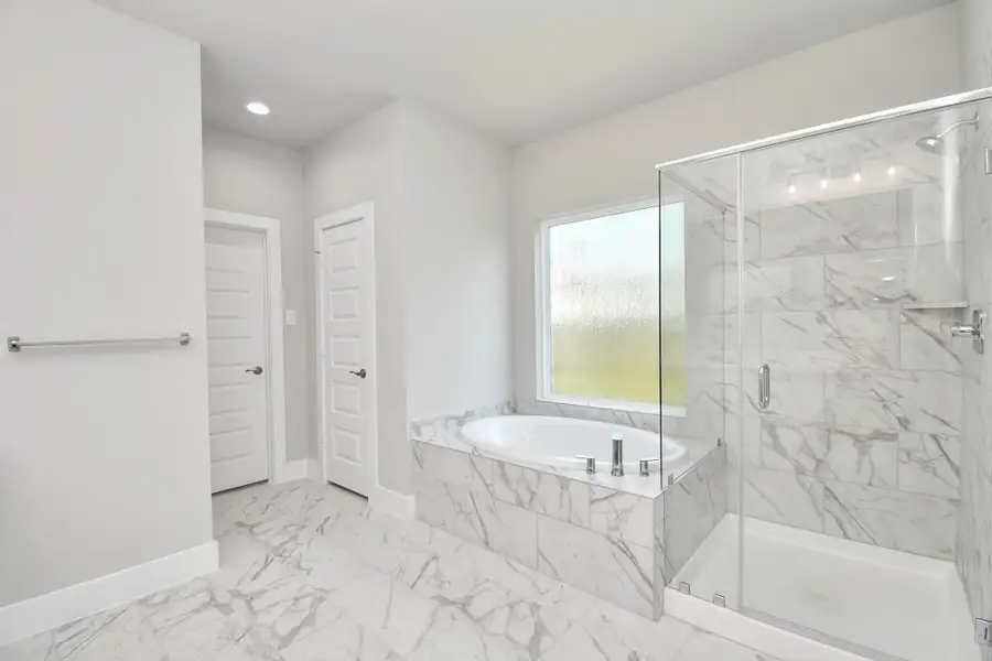 Indulge in a spa-like retreat within the confines of this primary bathroom. Delight in a spacious walk-in shower enveloped in stylish tile surround and unwind in a separate garden tub adorned with custom detailing. Indulge in a spa-like retreat within the confines of this primary bathroom. Delight in a spacious walk-in shower enveloped in stylish tile surround and unwind in a separate garden tub adorned with custom detailing.