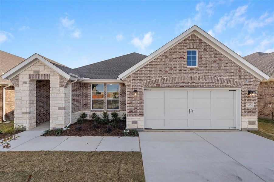 Ranch-style house featuring roof with shingles, brick siding, concrete driveway, and stone siding Ranch-style house featuring roof with shingles, brick siding, concrete driveway, and stone siding