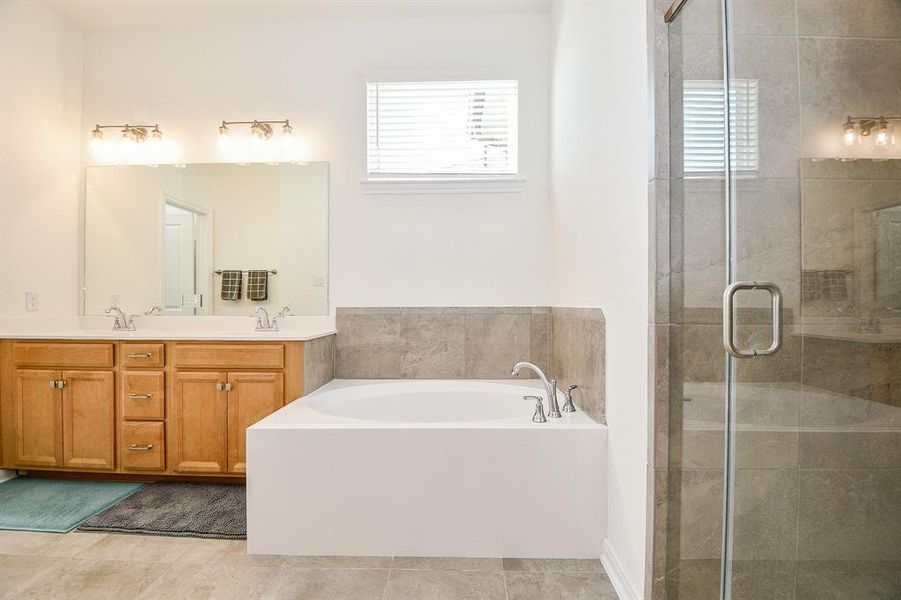 Relax and soak your worries away in this luxurious soaking tub or enjoy a quick rinse in the spacious walk-in shower with sleek frameless glass. Either way, you'll love this private retreat.