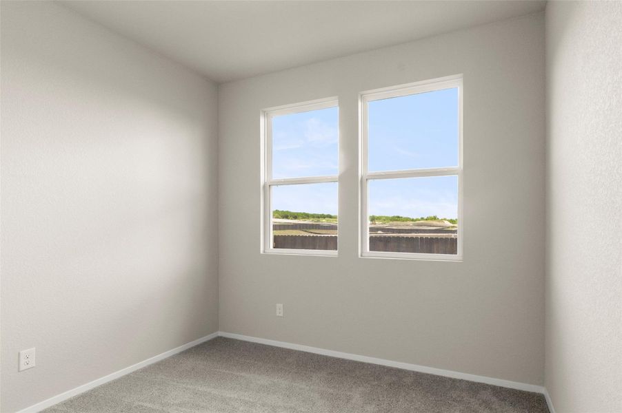 Carpeted empty room featuring baseboards