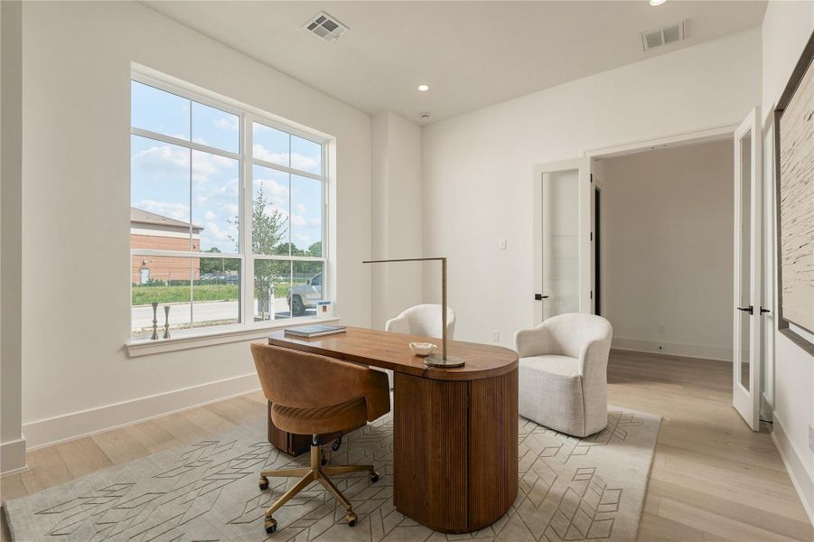 The home office balances privacy with openness, featuring generous proportions and oversized windows that bring natural light into the workspace.