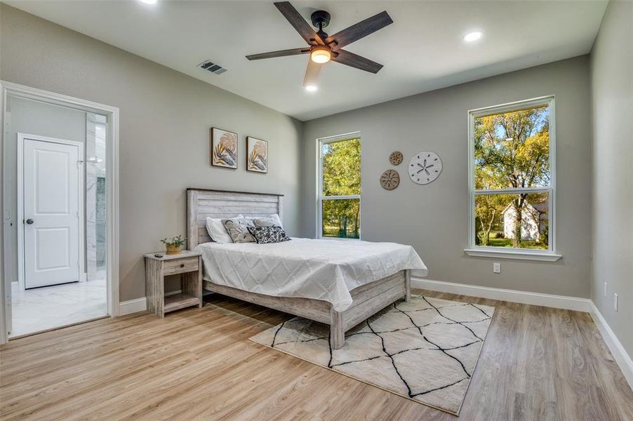 Bedroom with light wood finished floors, multiple windows, a ceiling fan, and recessed lighting