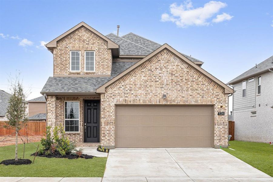 View of front of property with brick siding, a shingled roof, an attached garage, fence, and a front yard