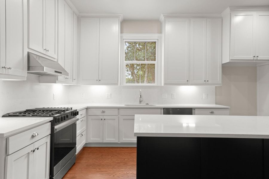 Well-appointed kitchen offers sleek white cabinetry, stainless steel appliances, and ample counter space. Well-appointed kitchen offers sleek white cabinetry, stainless steel appliances, and ample counter space.