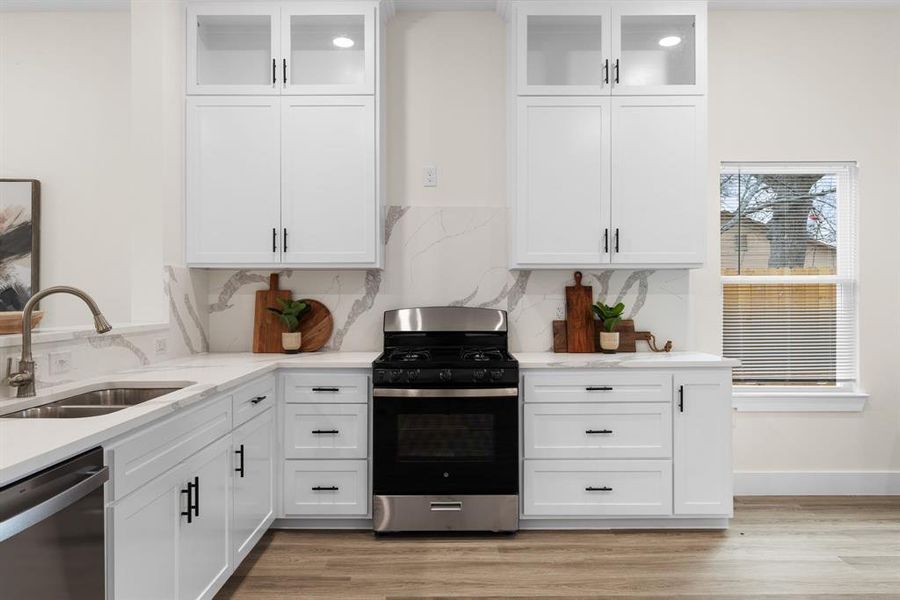 Kitchen with sink, white cabinetry, and stainless steel appliances