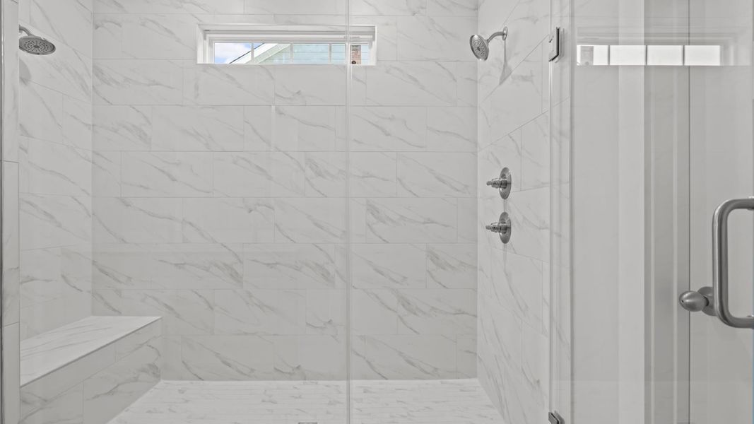 Spacious and modern primary bathroom with tiled walk-in Roman shower and first-class double vanity setup