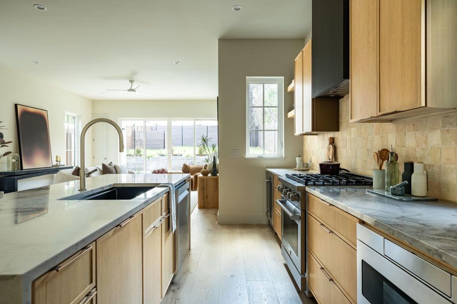 Natural wood cabinetry and stone countertops elevate this bright, open kitchen space. Natural wood cabinetry and stone countertops elevate this bright, open kitchen space.
